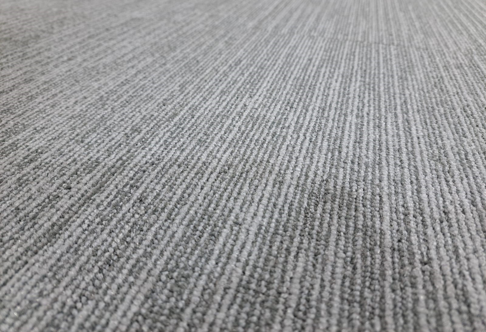 Low-angle photograph showing carpet-tile texture, pile and edge